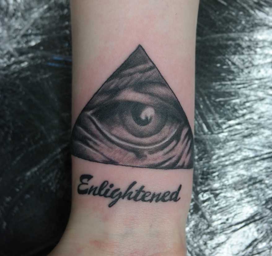 Tatuagem no pulso da menina - a pirâmide com o olho