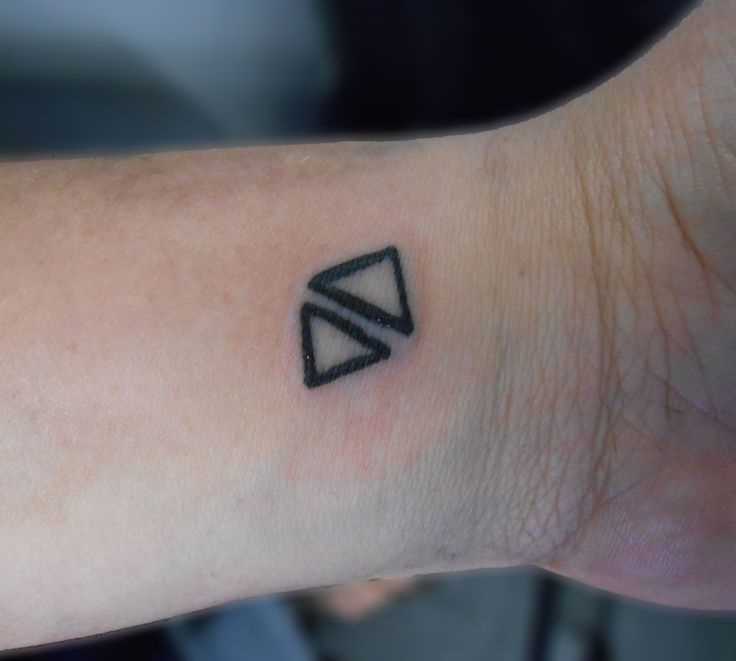 Tatuagem no pulso da menina - dois triângulos