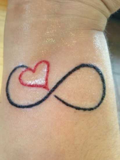 Tatuagem no pulso da menina - o coração e o infinito