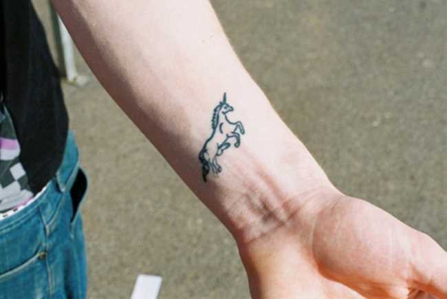 Tatuagem no pulso da menina - que é um unicórnio