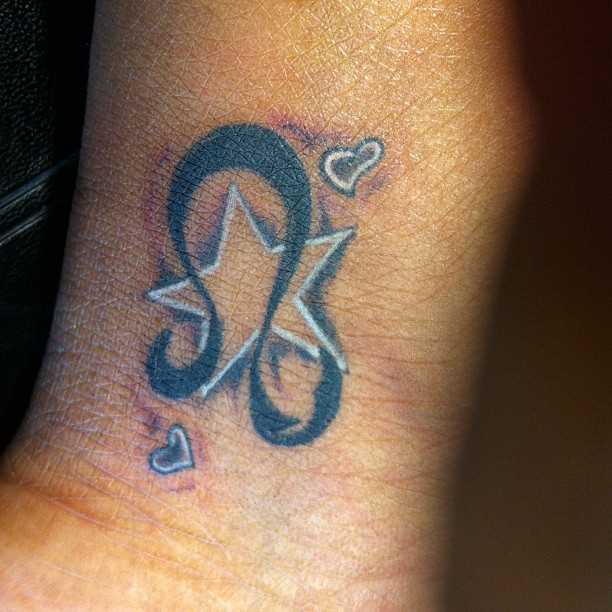 Tatuagem no pulso da menina - signo de leão, estrela e corações