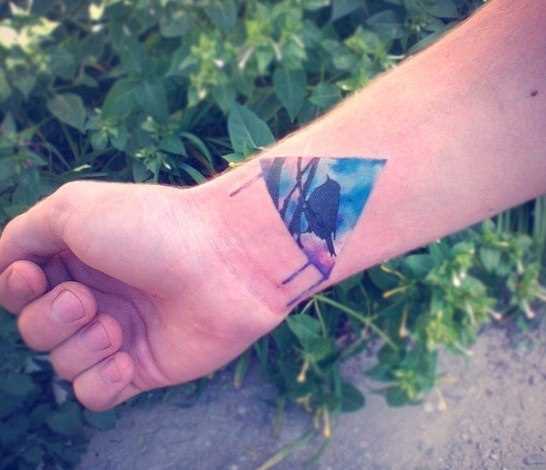 Tatuagem no pulso da menina - triângulo com o pássaro dentro