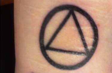 Tatuagem no pulso da menina - triângulo com um círculo