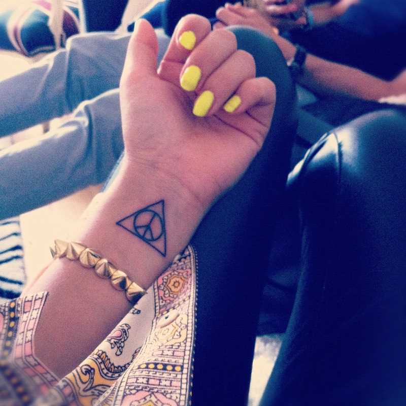 Tatuagem no pulso da menina - triângulo e grug