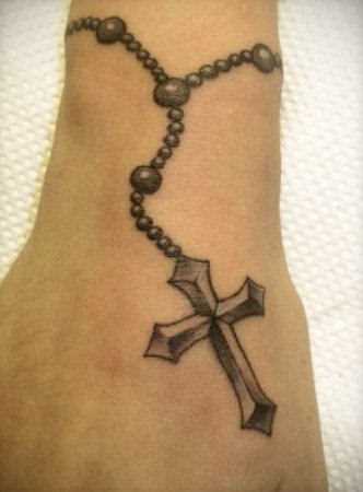 Tatuagem no pulso da menina - um colar com uma cruz