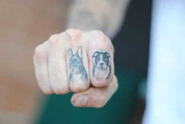 Tatuagem nos dedos de um cara de cabeça do cão