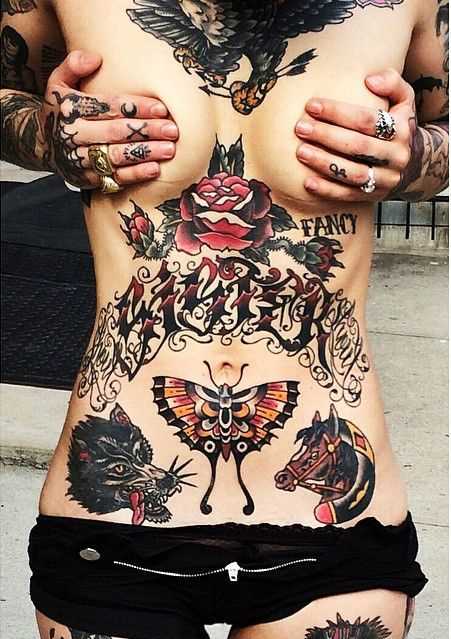 Tatuagem oldschool na barriga da menina - lobo, cavalo e uma borboleta