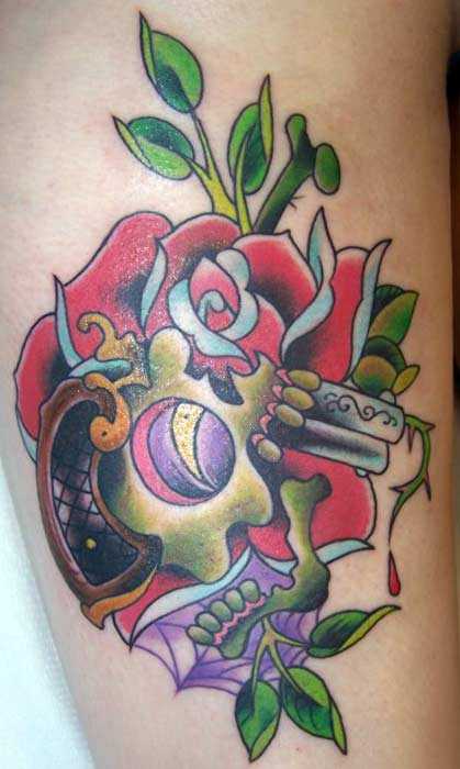 Tatuagem que a menina nos quadris em forma de pistola, caveiras e rosas