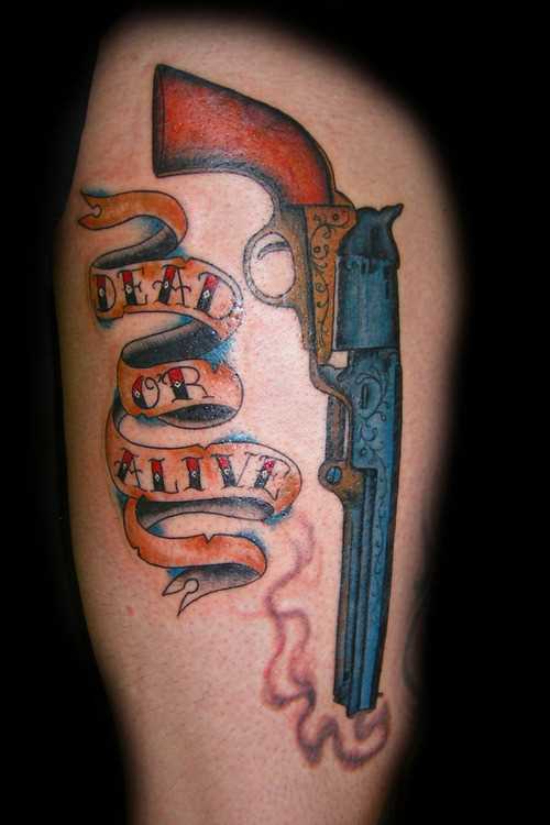 Tatuagem que a menina nos quadris em forma de pistola e inscrições