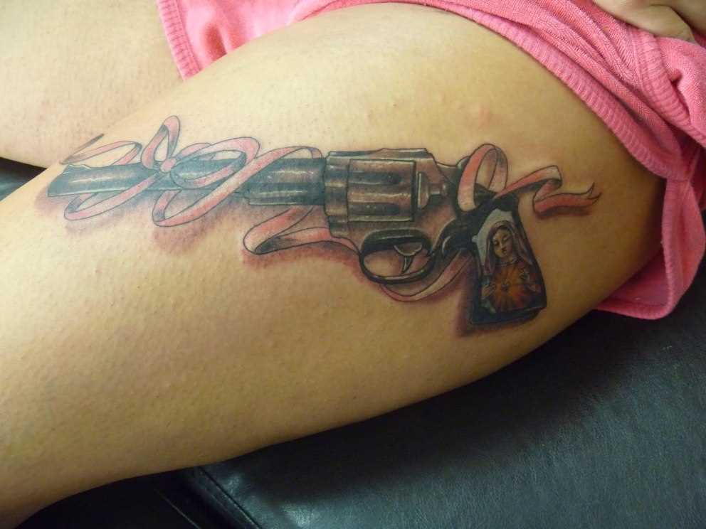 Tatuagem que a menina nos quadris - pistola e granadas