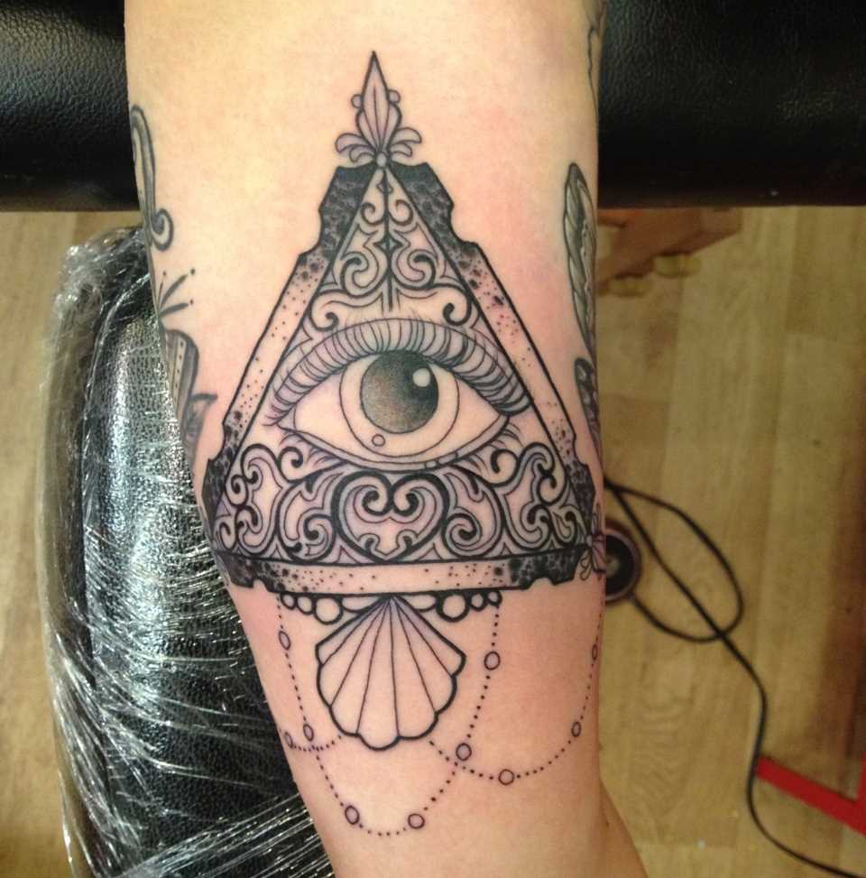 Tatuagem que tem no braço da menina - a pirâmide e o olho