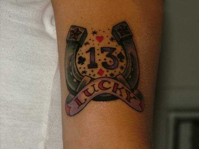 Tatuagem que tem no braço da menina - ferradura, a inscrição e o número 13
