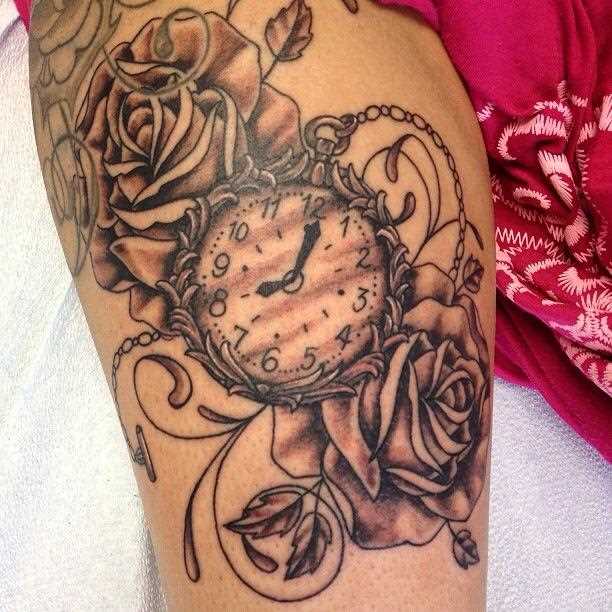 Tatuagem que tem no braço da menina - relógio de bolso e rosas