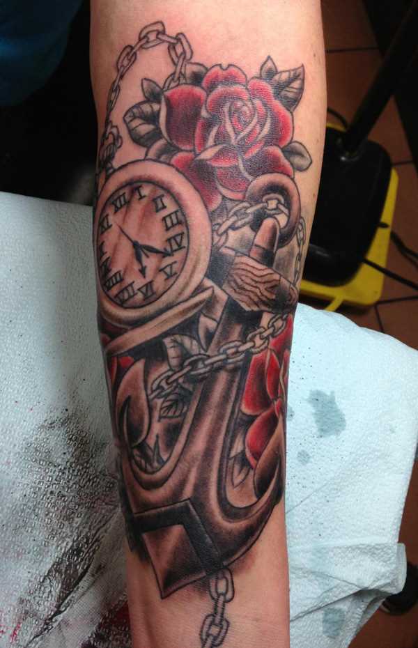 Tatuagem que tem no braço da menina - relógio de bolso, rosas e âncora
