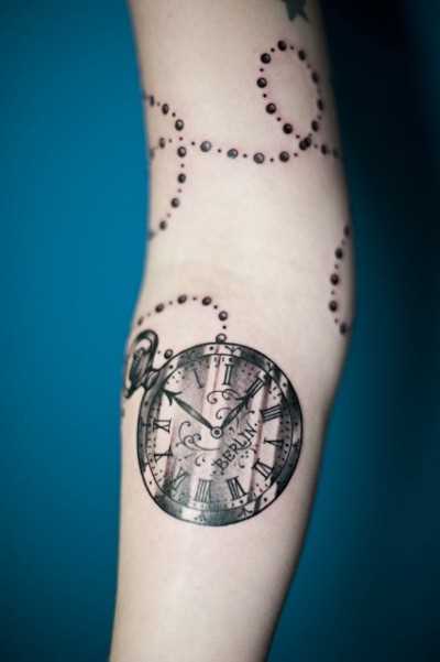 Tatuagem que tem no braço da menina - um colar com relógio