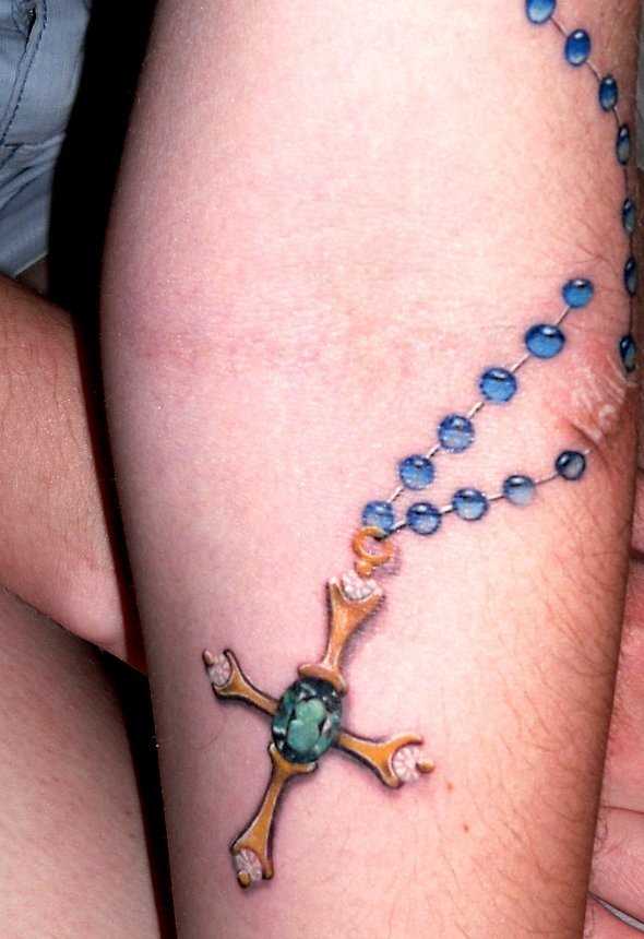 Tatuagem que tem no braço da menina - um colar com uma cruz
