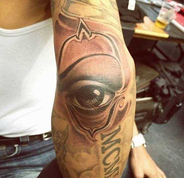 Tatuagem - uma imagem de olho no estilo chicano no cotovelo do cara