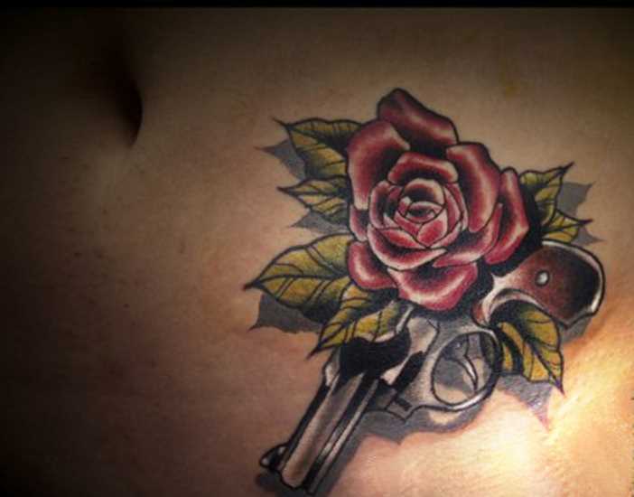 Uma bela tatuagem em seu lado da menina - arma e rosa