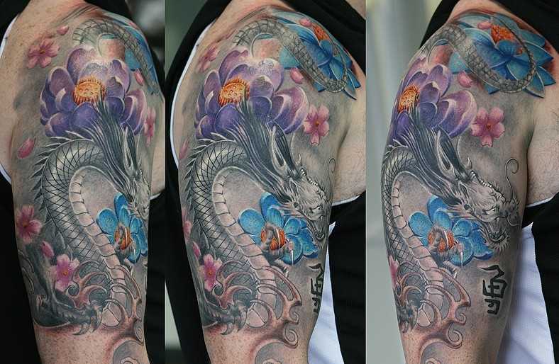 Uma bela tatuagem em seu ombro o homem - dragão, sakura e de lótus