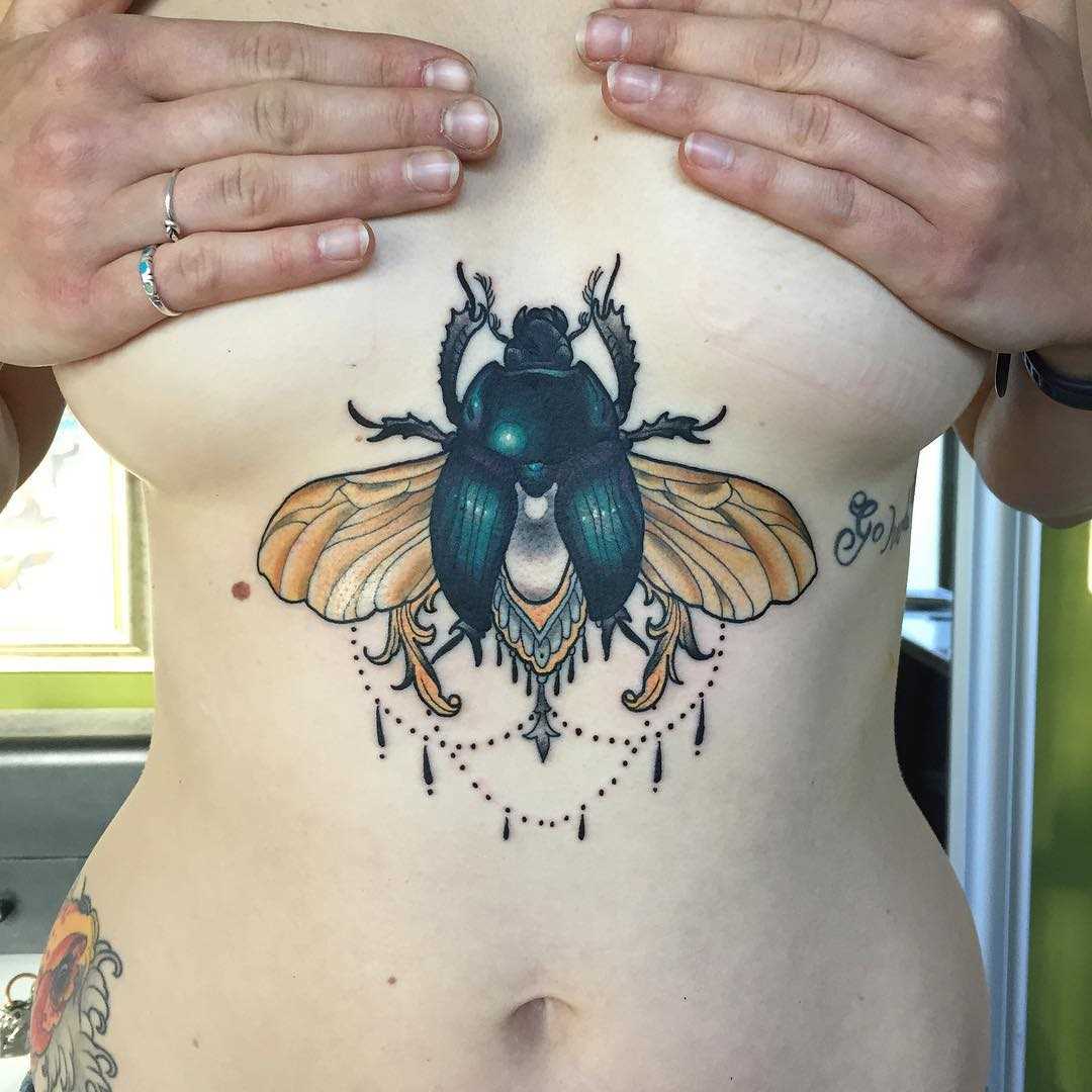 Uma belíssima imagem de escaravelho no peito da menina