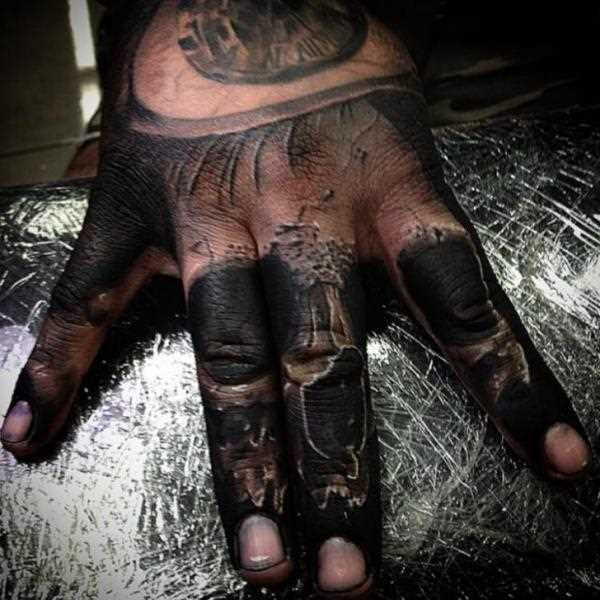 Uma imagem de uma caveira em que os dedos de um cara - de tatuagem chicano
