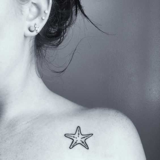 Uma pequena tatuagem de estrela do mar na clavícula menina