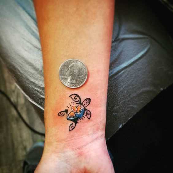 Uma pequena tatuagem de uma tartaruga no pulso da menina