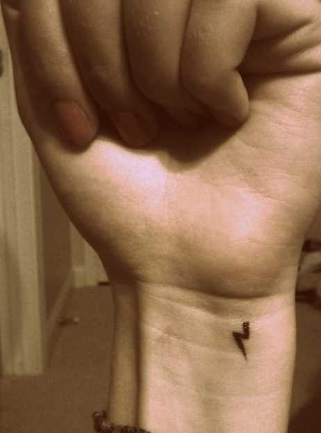 Uma pequena tatuagem no pulso da menina - relâmpago