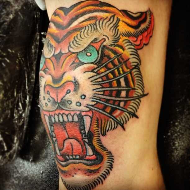 Uma tatuagem de tigre em estilo oldschool no joelho da menina