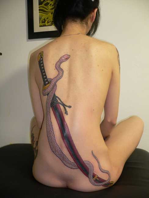 Uma tatuagem em forma de cobra e uma espada nas costas da menina