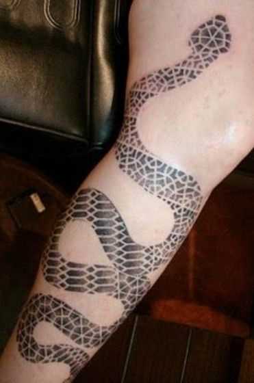 Uma tatuagem em forma de cobra na perna da menina