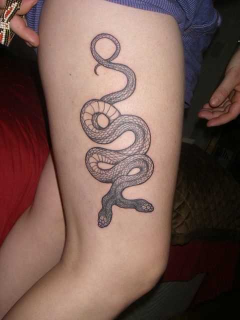 Uma tatuagem em forma de cobra nas coxas da menina