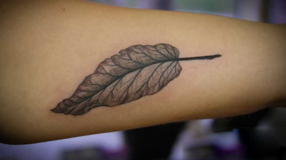 Uma tatuagem em forma de folha na mão da menina