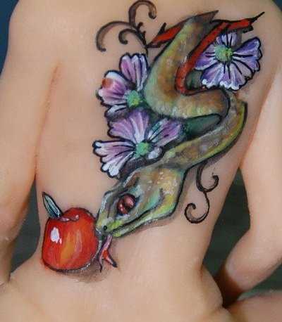 Uma tatuagem em forma de serpente, a maçã e a cores na parte de trás da menina