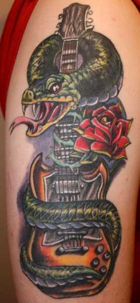 Uma tatuagem em forma de serpente, guitarra e rosa no ombro da menina