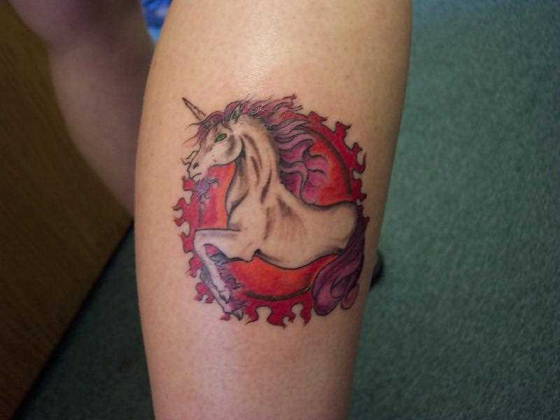 Uma tatuagem em forma de unicórnio sobre a perna de uma menina