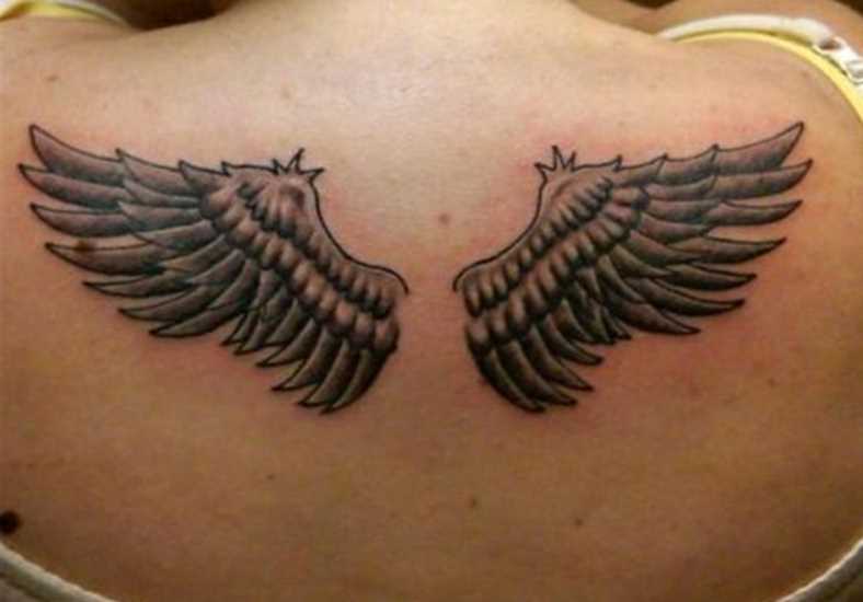 Uma tatuagem que a menina nas costas em forma de asas
