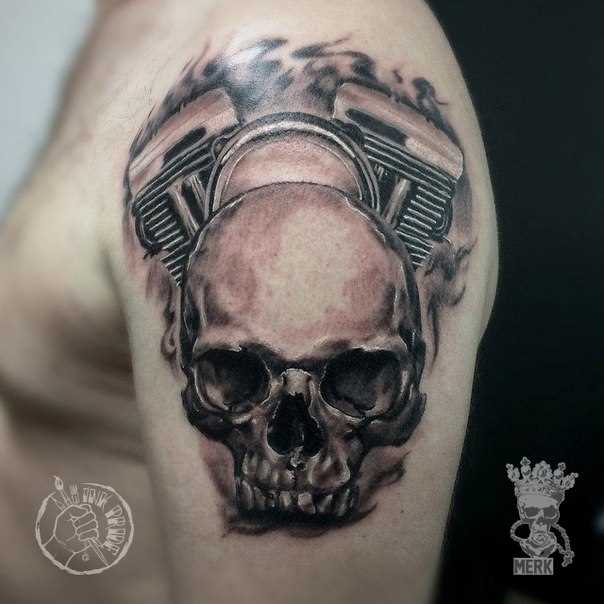 Motociclista tatuagem com o crânio e o motor no ombro do cara