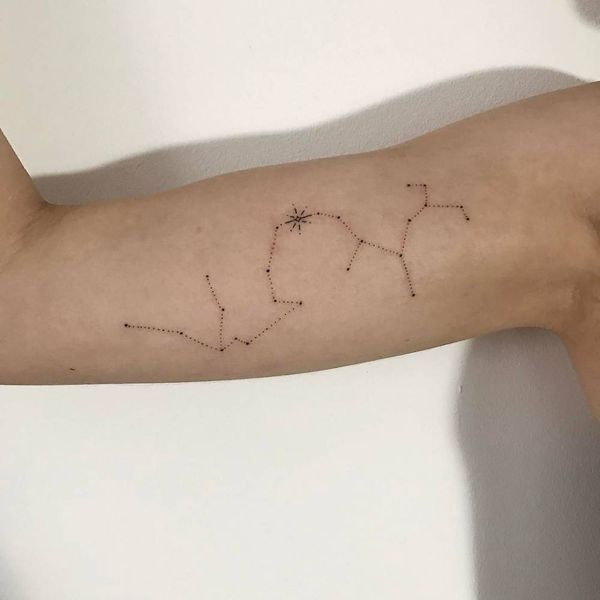 Tatuagem impressionante de Sagitário e Aquário no bíceps interno