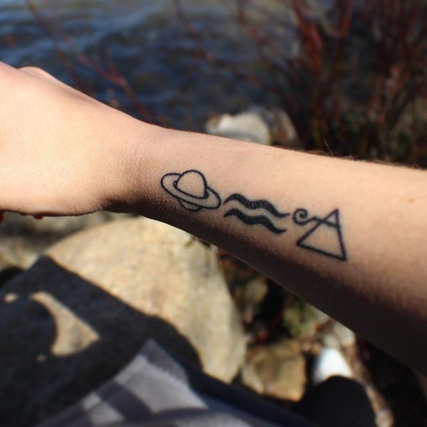 Tatuagens de símbolos impressionantes de Aquário, Saturno e ondas de ar perto do pulso